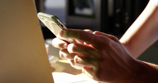 Person Using Smartphone Beside Laptop in Sunlit Room - Download Free Stock Images Pikwizard.com