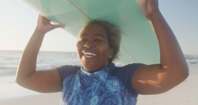 Joyful woman carrying surfboard on sunny beach - Download Free Stock Images Pikwizard.com