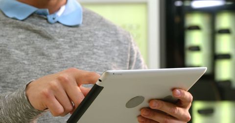 Midsection of male optometrist using tablet in optical office