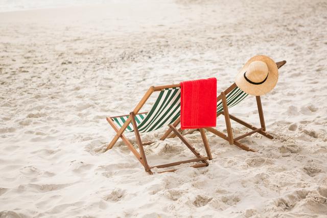 Straw hat and towel kept on beach chairs at tropical sand beach