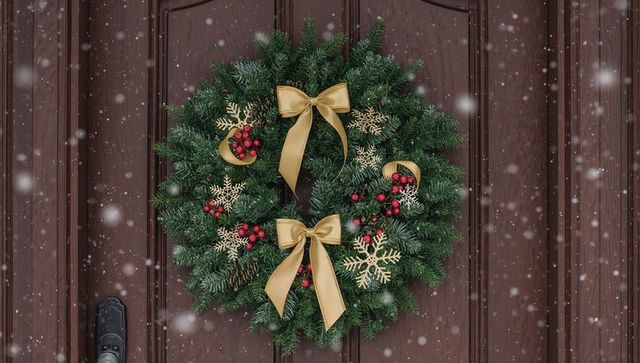 Festive Holiday Wreath with Gold Ribbon on Snowy Wooden Door
