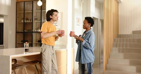 Sharing morning coffee in modern kitchen, friends chatting over french press