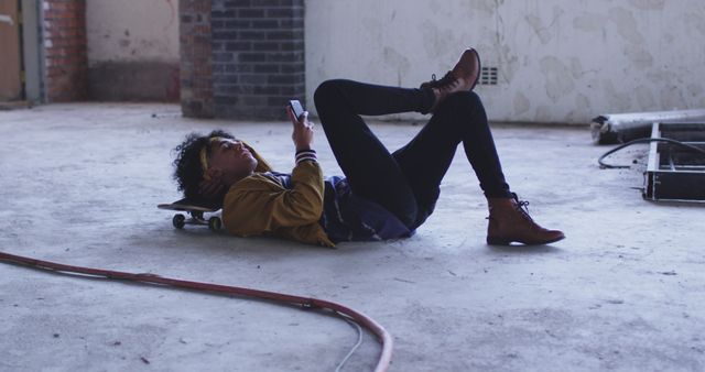Teen Laying on Skateboard Using Smartphone in Empty Room - Download Free Stock Images Pikwizard.com