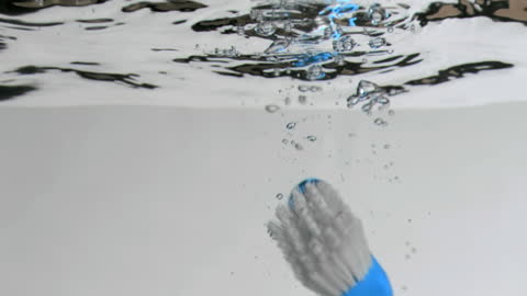 Toothbrush Rising Slowly Through Clean Water