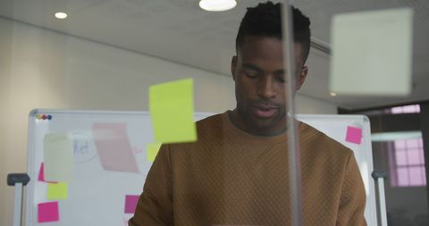 Pensive businessman with sticky notes develops creative ideas