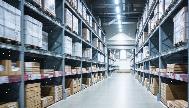 Expansive distribution center aisle showing organized pallet racking and labeled boxes