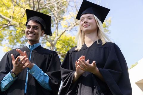 Diverse graduates applauding with academic pride