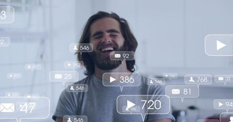Laughing bearded man surrounded by social media engagement bubbles in modern kitchen