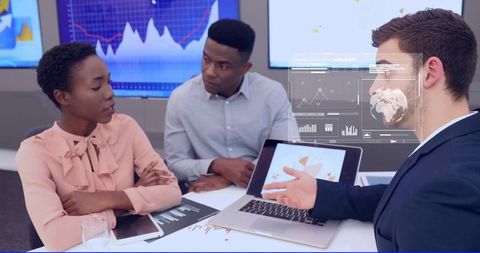 Diverse business team discussing data analytics and strategy around laptop dashboard