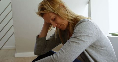 Contemplative Woman Sitting Indoors in Thoughtful Moment - Download Free Stock Images Pikwizard.com