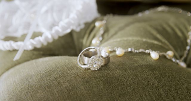 Close up of wedding rings and white transparent cloth on pillow. Wedding, celebration and jewellery.