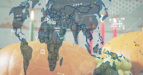 Autumn pumpkins blending with world map data overlay and warm candle bokeh