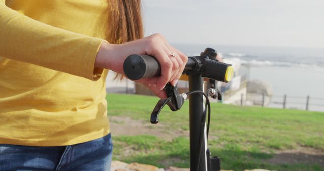 Woman Wearing Yellow Sweater Riding Electric Scooter Near Beach - Download Free Stock Images Pikwizard.com