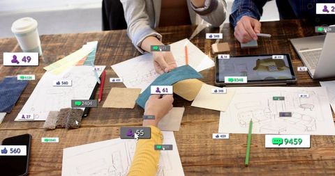 Interior design team comparing fabric swatches with digital sketches on rustic table