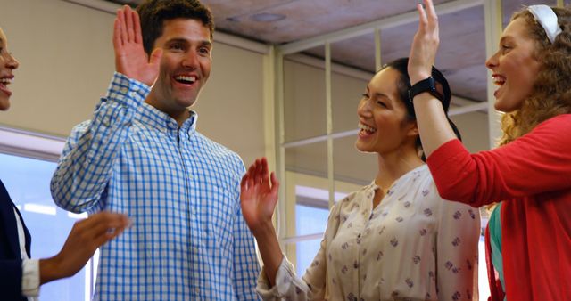 Cheerful Coworkers High-Fiving in Modern Office - Download Free Stock Images Pikwizard.com