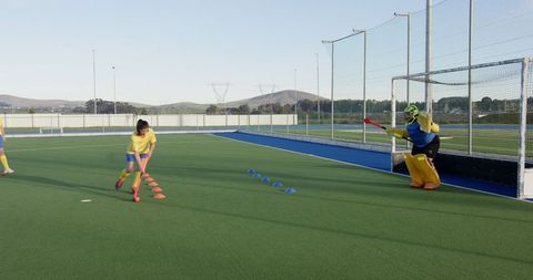 Girls Practicing Field Hockey Skills on Turf
