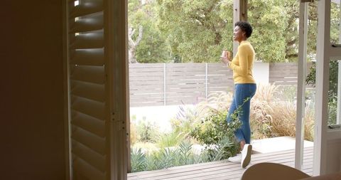 African American Woman Relaxing with Coffee on Outdoor Deck