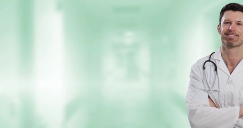 Confident male doctor in hospital corridor