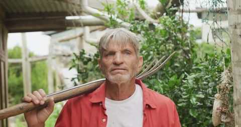Senior man gardening outdoors with fork