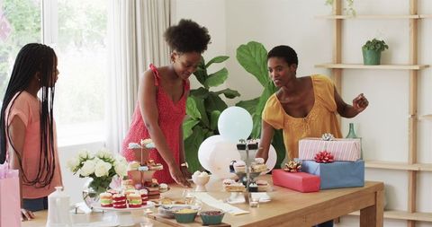 Women Joyfully Preparing for Baby Shower with Gifts and Desserts