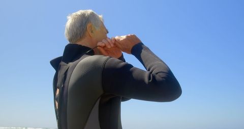 Senior surfer preparing for adventure on sunny beach