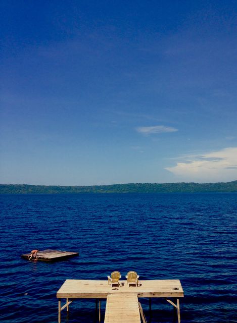 Peaceful Lake Dock with Chairs Overlooking Blue Water and Clear Sky - Download Free Stock Images Pikwizard.com