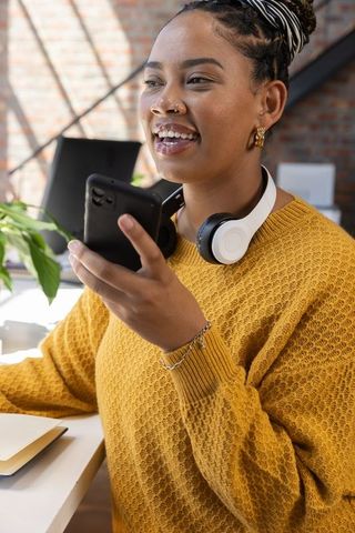 Creative professional woman at desk in modern brick-walled office
