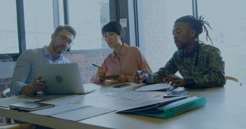Diverse Professionals Analyzing Reports in Modern Meeting Room