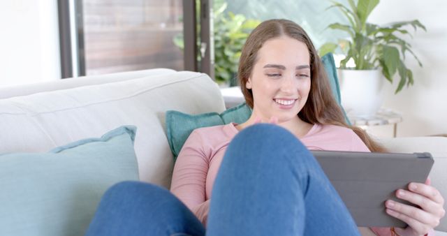 Young Woman Relaxing on Sofa and Using Tablet - Download Free Stock Images Pikwizard.com