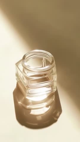 Vertical video sunlight through hexagonal glass jar with soft shadows and refractions