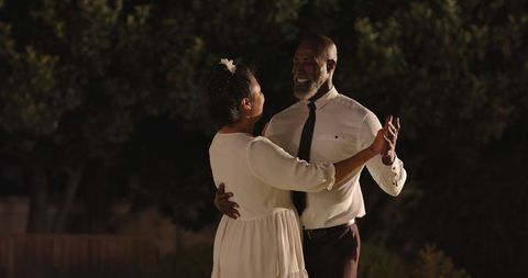 Senior Couple Dancing in Magical Garden at Night