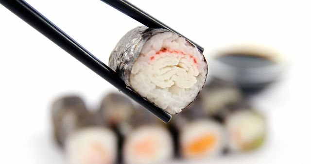 Close-up of Crab Roll Sushi Held by Black Chopsticks - Download Free Stock Images Pikwizard.com