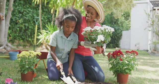Happy african american mother and daughter gardening together. Lifestyle, domestic life, hobby, family, and togetherness.