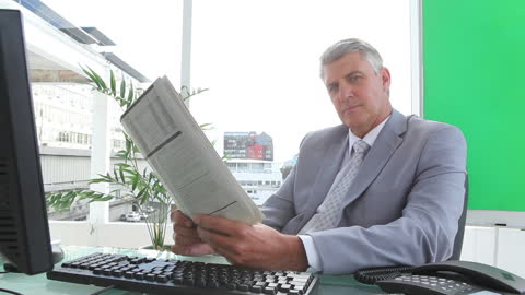 Sophisticated Businessman Reading Newspaper in Modern Office
