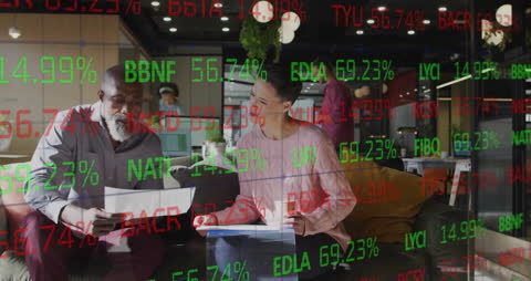 Colleagues Discussing Work with Stock Market Projections Overlay