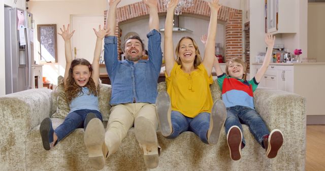 Happy Family Sitting On Sofa Raising Hands Celebrating - Download Free Stock Images Pikwizard.com