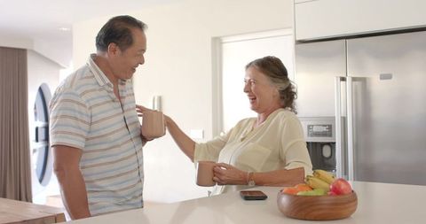 Senior Couple Enjoying Coffee and Laughter in Contemporary Kitchen