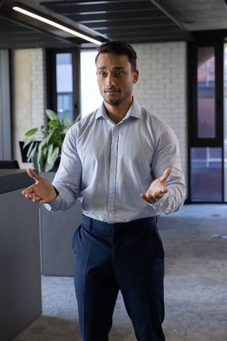 Confident businessman presenting modern office space