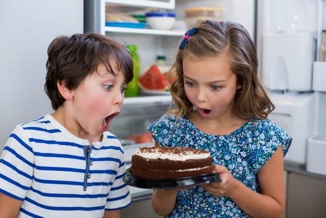 Surprised Siblings Discovering Cake in Kitchen - Download Free Stock Photos Pikwizard.com
