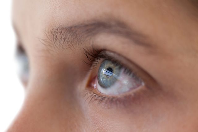 Close-up of girls eye and nose against white background