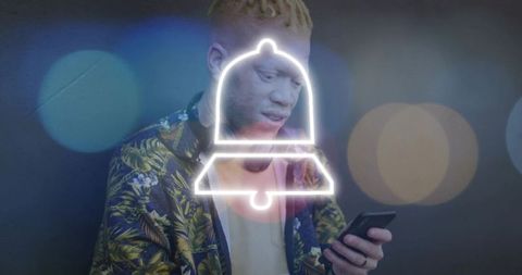 Man viewing neon notification bell overlay while using smartphone in botanical jacket