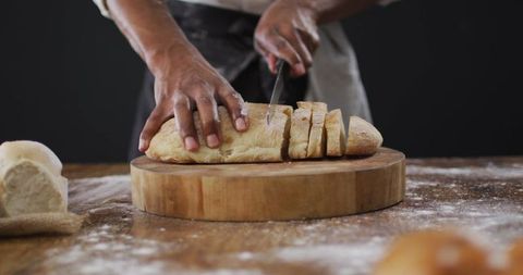 Chef slicing freshly baked bread in rustic kitchen atmosphere
