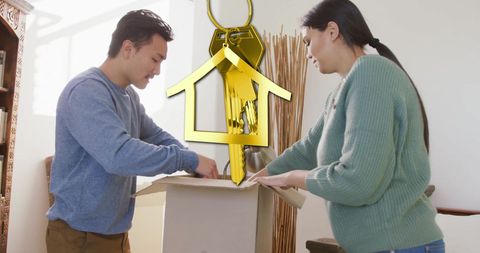 Couple unpacking boxes in new home with gold key icon overlay
