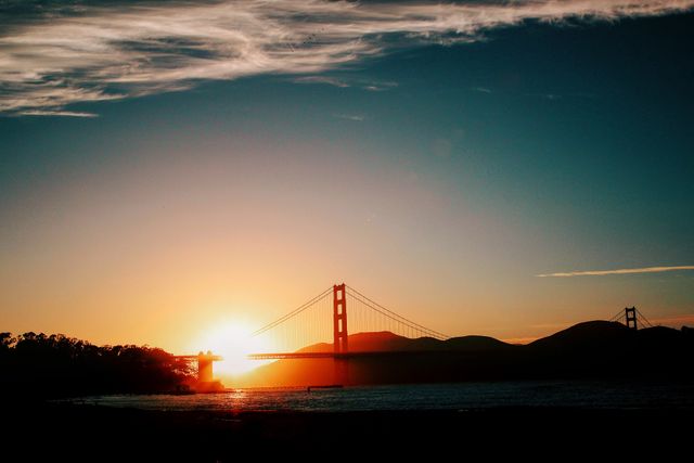 This image showcases the Golden Gate Bridge at sunset with a dramatic sky and glowing horizon. Ideal for travel blogs, tourism promotions, and articles highlighting iconic landmarks in San Francisco. Excellent for use in backgrounds, postcards, and scenic presentations.