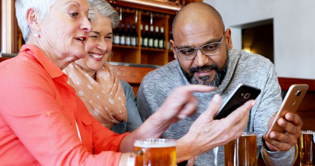 Senior Friends Enjoying Drinks and Viewing Smartphones Together - Download Free Stock Images Pikwizard.com