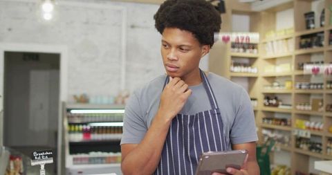 Retail clerk reviewing inventory with digital tablet in store environment