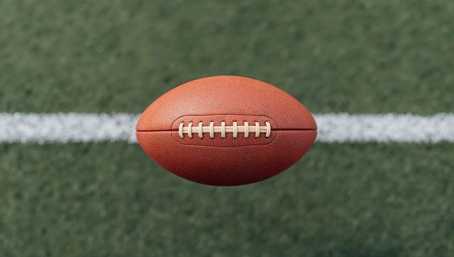 American Football Mid-Air Above Turf Field Yard Line