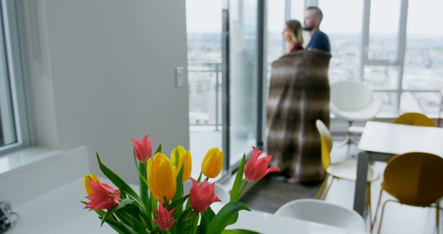 Couple Enjoying City View from Modern Apartment with Flower Decor - Download Free Stock Images Pikwizard.com