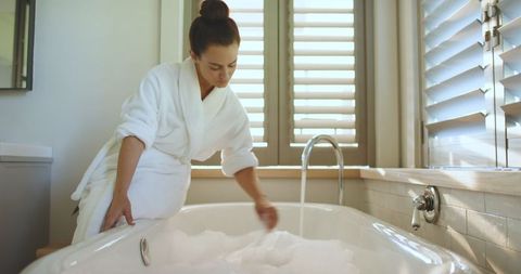 Woman Creating Relaxing Foam Bath in Luxurious Home Bathroom