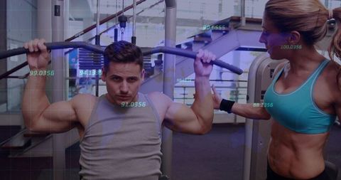 Man performing lat pulldown while female trainer guiding with digital fitness overlay